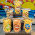 Assorted bags of popcorn with colorful labels against a vibrant mural background