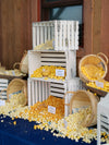 Popcorn bar with bulk Jalapeno Cheddar, Chicago Pizza and Classic Butter popcorn in crates and baskets